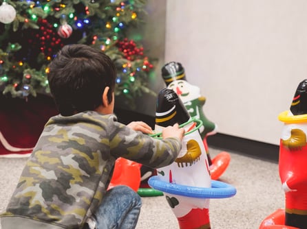 child playing with ring toss game